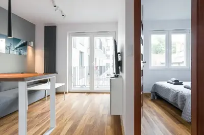 a white bedroom with a desk and a bed at Modern and comfortable with a bedroom in Kraków
