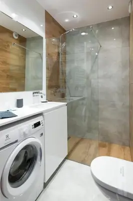 a bathroom with a washing machine and a shower at Modern and comfortable with a bedroom in Kraków
