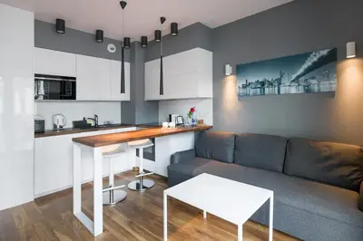 a kitchen and living room with a couch and a table at Modern and comfortable with a bedroom in Kraków