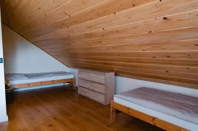 two beds in a room with a wooden ceiling at NOVMI - Domki letniskowe