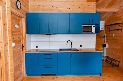 a kitchen with blue cabinets and a sink at NOVMI - Domki letniskowe