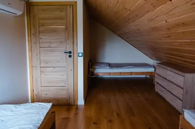 a room with a bed and a wooden door at NOVMI - Domki letniskowe