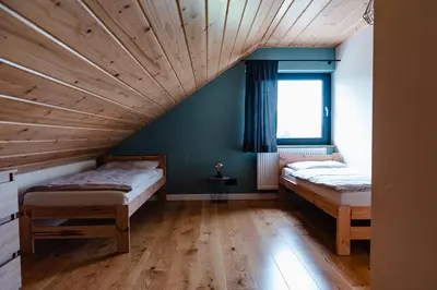 two beds in a room with a wooden ceiling at NOVMI - Domki letniskowe