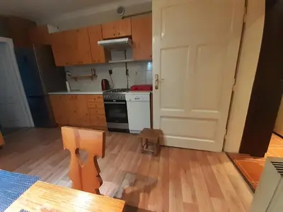 a kitchen with a door open to a kitchen with wooden floors at Sienna 3 OLD TOWN in Kraków