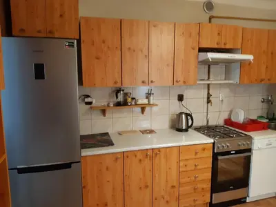 a kitchen with wooden cabinets and a stainless steel refrigerator at Sienna 3 OLD TOWN in Kraków