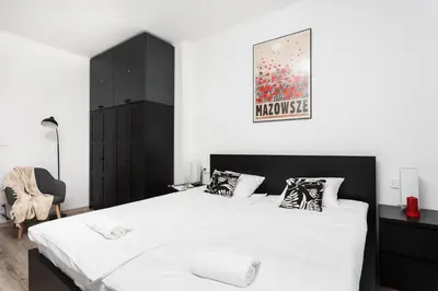 a bedroom with a large white bed and a black cabinet at Cosy Corner - Kraków, Krowodrza - by Upstairs in Kraków