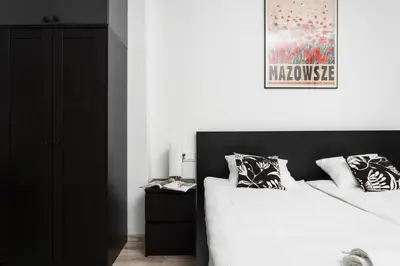 a bedroom with a black and white bed and a picture at Cosy Corner - Kraków, Krowodrza - by Upstairs in Kraków
