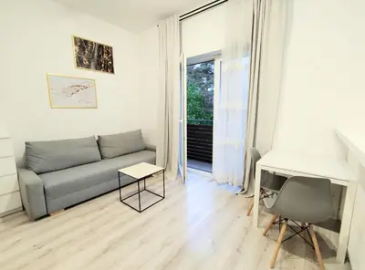 a living room with a couch and a desk and a window at White Studio in Wieliczka