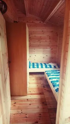 a small room with a bed in a wooden cabin at Gościniec nad Zalewem Sosina in Jaworzno