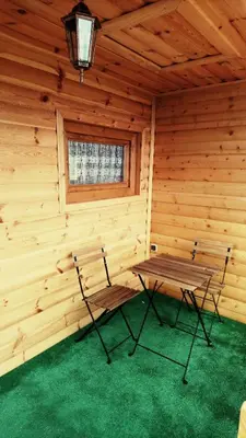 a wooden cabin with a table and chairs in it at Gościniec nad Zalewem Sosina in Jaworzno