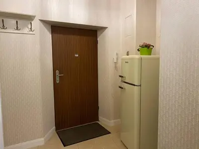 a kitchen with a refrigerator and a wooden door at Radiance Residence in Kraków