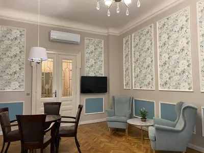 a living room with chairs and a table and a tv at Radiance Residence in Kraków