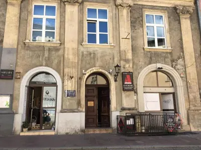 an old building with three arches on the front of it at Radiance Residence in Kraków