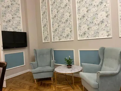 a living room with two chairs and a table and a tv at Radiance Residence in Kraków