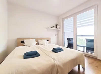 a bedroom with a large bed with two blue towels on it at Sołtysa Dytmara 3 by Homeprime in Kraków
