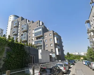 a tall building with cars parked in a parking lot at Sołtysa Dytmara 3 by Homeprime in Kraków