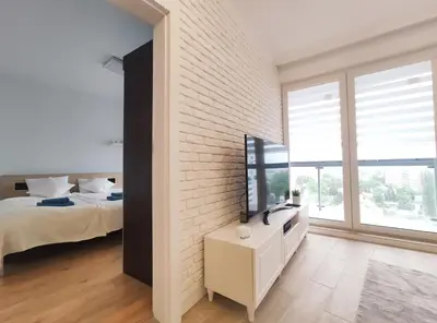 a bedroom with a bed and a white brick wall at Sołtysa Dytmara 3 by Homeprime in Kraków