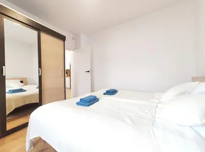 a bedroom with a white bed and a mirror at Sołtysa Dytmara 3 by Homeprime in Kraków