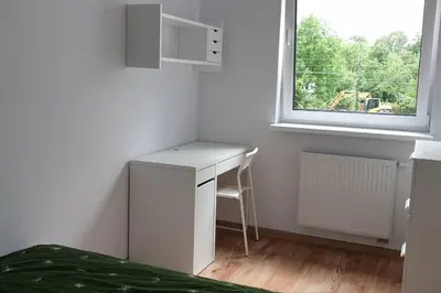 a white desk in a room with a window at Wygodny apartament niedaleko centrum by Krakow Home in Kraków