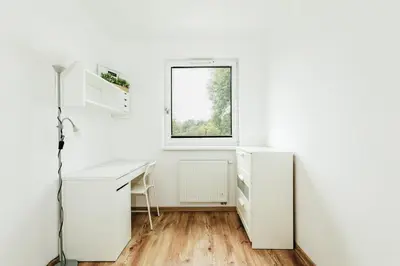a white office with a desk and a window at Wygodny apartament niedaleko centrum by Krakow Home in Kraków