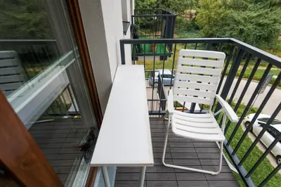 a white table and two chairs on a balcony at Wygodny apartament niedaleko centrum by Krakow Home in Kraków