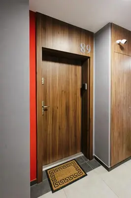 a large wooden door with a sign on it at Wygodny apartament niedaleko centrum by Krakow Home in Kraków