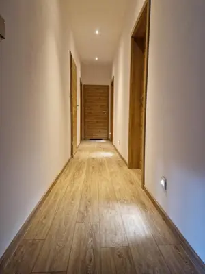 an empty hallway with wooden floors and a wooden door at Dom nad Stryszawką z SAUNĄ - domek wypoczynkowy in Stryszawa