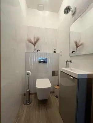 a white bathroom with a toilet and a sink at Dom nad Stryszawką z SAUNĄ - domek wypoczynkowy in Stryszawa