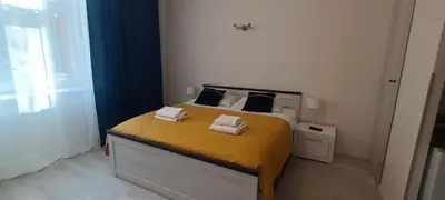 a bedroom with a green bed with towels on it at Central Cracow Apartments in Kraków