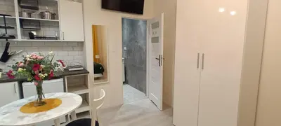 a kitchen with a table with a vase of flowers on it at Central Cracow Apartments in Kraków