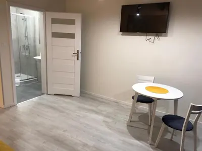 a room with a table and two chairs and a television at Central Cracow Apartments in Kraków