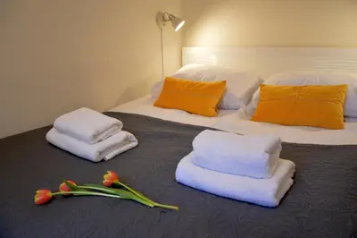 a hotel room with towels and flowers on a bed at Central Cracow Apartments in Kraków