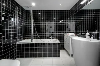 a black tiled bathroom with a tub and a toilet at Apartament Romantyczny Zamkowa15 in Kraków