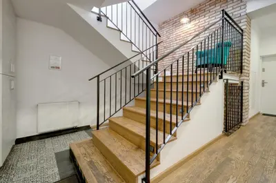 a staircase in a loft with a brick wall at Apartament Romantyczny Zamkowa15 in Kraków