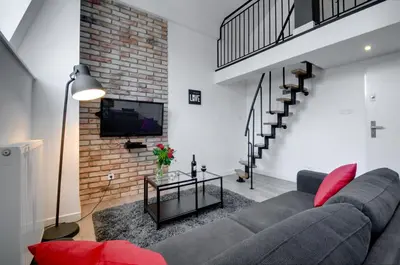 a living room with a couch and a brick wall at Apartament Romantyczny Zamkowa15 in Kraków