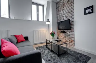 a living room with a couch and a brick wall at Apartament Romantyczny Zamkowa15 in Kraków