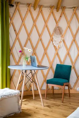 a table with a laptop and a chair in a room at Jurta Jura polna in Przybysławice