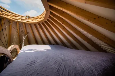 a bed in a tent with a round window at Jurta Jura polna in Przybysławice