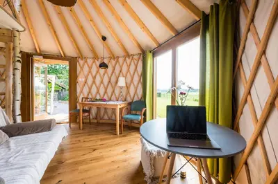a room with a bed and a laptop on a table at Jurta Jura polna in Przybysławice