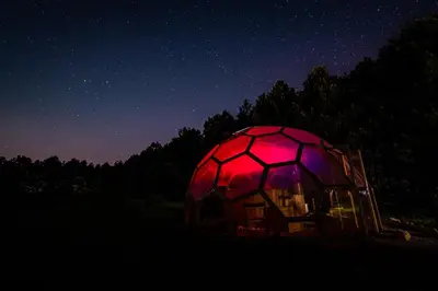 a red and black dome tent in a field at night at Jurta Jura polna in Przybysławice