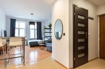 a living room with a table and a mirror at Lubomirskiego 9 in Kraków