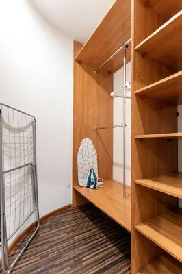a walk in closet with wooden shelves and a crib at Lubomirskiego 9 in Kraków
