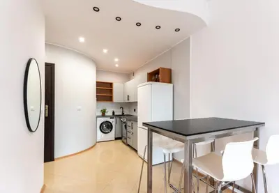 a kitchen with a black table and white appliances at Lubomirskiego 9 in Kraków