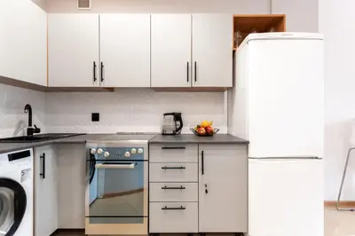 a kitchen with white cabinets and a refrigerator at Lubomirskiego 9 in Kraków