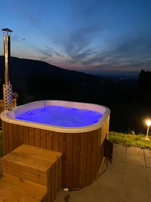 a jacuzzi tub sitting on a patio at night at Forest house in Targanice