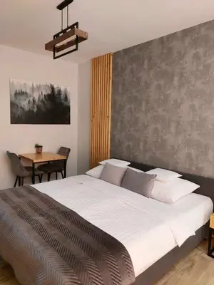 a bedroom with a large bed and a table at Zasankowe Wzgórze in Zasań