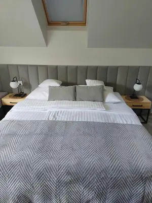 a large bed in a bedroom with two tables at Zasankowe Wzgórze in Zasań