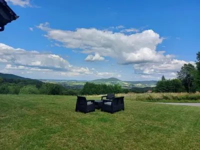 two black chairs sitting in a field of grass at Zasankowe Wzgórze in Zasań