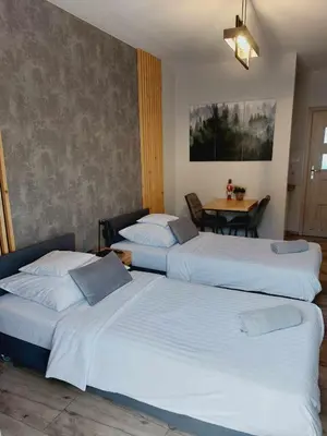 two beds in a hotel room with a table at Zasankowe Wzgórze in Zasań