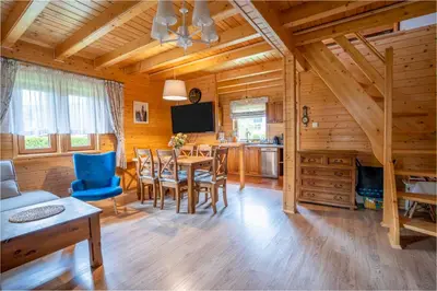 a dining room and living room with a table and chairs at Kamyczkowy domek w Zawoi in Zawoja